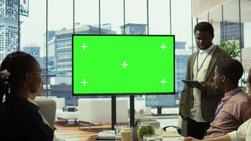 Employees and investors participating in a briefing next to isolated copy space display, reviewing economic indicators and performance metrics. Work team discussing finance planning. Camera B. video