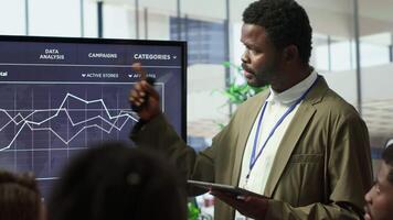 Coworkers engaging in a problem solving meeting at a corporation, using an interactive board to visualize data and develop solutions for complex challenges. Analysis presentation. Camera A. video