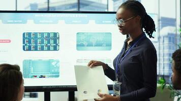 In a high end boardroom, employees gather to brainstorm ideas and create strategies, analyzing statistics to drive business development and ensure successful project. Enterprise solutions. Camera A. video