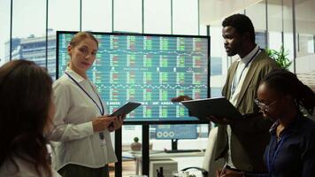 attività commerciale associati condivisione idee nel un' aziendale riunione incontro, utilizzando interattivo tavole per presente dettagliato progetto rapporti e allineare su chiave prestazione indicatori e obiettivi. telecamera b. video