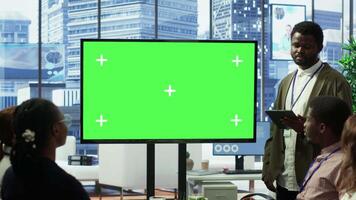 Diverse work team discusses corporate strategies with a big green screen, meeting in high end boardroom to examine market trends. Sharing new ideas for business growth and expansion. Camera A. video