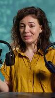 Vertical Audio technician presenting professional headphones in different price ranges to audience, comparing them to find winner. Expert recommending listening devices to fans, doing review, camera A video