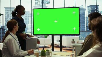 Diverse work team discusses corporate strategies with a big green screen, meeting in high end boardroom to examine market trends. Sharing new ideas for business growth and expansion. Camera B. video