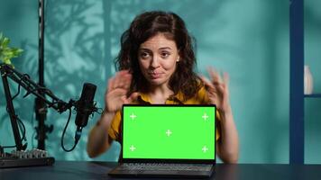 Woman in home studio using recording tech to capture live broadcast, reviewing mockup laptop. Internet show host filming electronics haul, presenting isolated screen notebook for viewers, camera A video