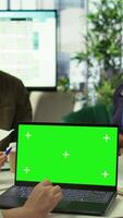 Vertical Diverse team of business associates looking at mockup chroma key screen during executive board meeting, utilizing smart technology. Enterprise staff develop effective business strategies. Camera B. video