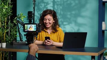 Streamer doing live broadcast, reading juicy text messages from her boyfriend, entertaining young audience. Influencer excited to read chat with crash on cellphone, talking with viewers, camera A video