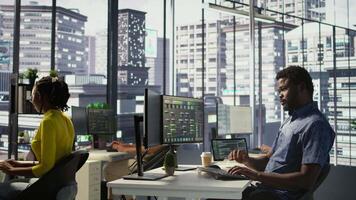 System administrator in office yawning during shift, feeling tired while looking at software interface on PC. Exhausted man being sleepy in workspace, programming on computer monitor, camera B video