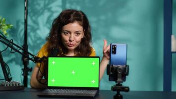 Internet show host being sponsored by partnering brand to do green screen laptop unboxing content. Tech specialist does influencer marketing, doing mockup notebook product placement, camera A video