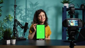 Woman filming tech tutorial on how to repair damaged mockup tablet using professional camera. Engineer teaching fans to install operating system on green screen device, recording with gear, camera B video
