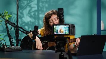 Content creator playing music on guitar during livestream with subscribers online. Skilled artist using acoustic musical instrument, doing internet concert for viewers, camera A video