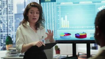 Coworkers engaging in a problem solving meeting at a corporation, using an interactive board to visualize data and develop solutions for complex business challenges. Analysis presentation. Camera A. video