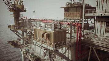 Old oil platform with red piping in offshore location during daylight hours video
