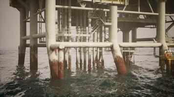 Old oil platform standing in the ocean with rusted support structures video