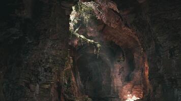 Exploring a hidden cave illuminated by natural light in a remote location video
