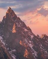 A mountain peak with snow on top photo