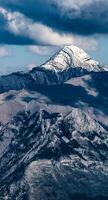 A mountain with a snow covered peak photo