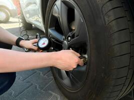 Man holding car tire pressure check equipment tool to checking low tire pressure inflating tires to or refill or air photo