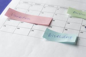 Calendar of the month and several colored adhesive notes to highlight the activities to be done. Copy space. Concept of time organization and achievement of objectives. photo