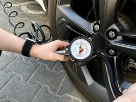 Man holding car tire pressure check equipment tool to checking low tire pressure inflating tires to or refill or air photo