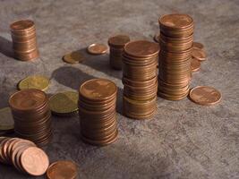 Euro money cents arranged in columns create striking display, with small coins scattered around. glimmer of metal reflects light, emphasizing value. A detailed view of money cents and their texture. photo