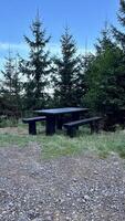 Wooden table with benches, a place for tourists to rest while hiking in the mountains photo