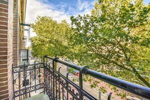 A balcony with a railing and a tree in the background photo