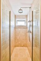 A walk in shower with a window and a toilet photo