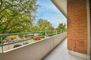 A balcony with a railing and trees in the background photo
