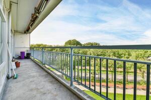A balcony with a railing and a bench photo