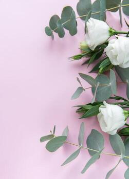 suave blanco rosas y eucalipto hojas arreglado en un ligero rosado fondo, Perfecto para un Boda o evento decoración foto