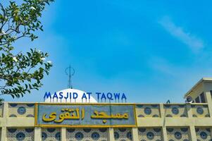 Facade of Masjid At Taqwa with blue sky, showcasing Islamic architecture and cultural heritage. translation on mosque The name of masjid at taqwa photo