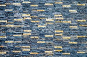 Textured stone wall with contrasting dark and light bricks, ideal for backgrounds and architectural designs photo