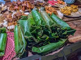 Traditional Indonesian angkringan stall with banana leaf-wrapped rice and assorted skewers, showcasing vibrant street food culture photo