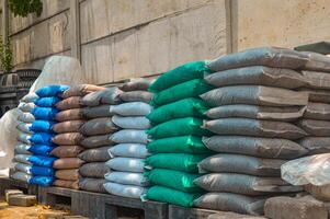Stacked colorful fertilizer bags on a pallet, showcasing various types for agricultural use. Essential supplies for farming and gardening photo