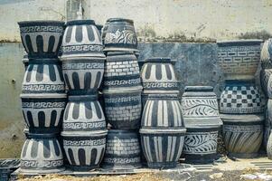 Stacked decorative concrete planters with ethnic patterns in an outdoor setting, showcasing artisanal garden decor photo
