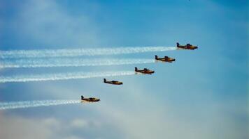 Formation of five Bonanza planes with smoke trails against blue sky, showcasing aerial skill and coordination, Surabaya, 22 September 2024. photo