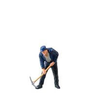 Miniature worker, wearing a blue jacket and cap, bends over while striking the ground isolate on white background with clipping path photo