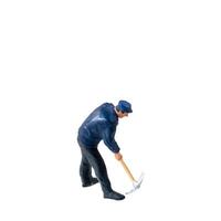 Miniature worker, wearing a blue jacket and cap, bends over while striking the ground isolate on white background with clipping path photo