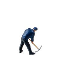 Miniature worker, wearing a blue jacket and cap, bends over while striking the ground isolate on white background with clipping path photo