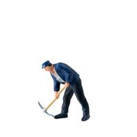 Miniature worker, wearing a blue jacket and cap, bends over while striking the ground isolate on white background with clipping path photo