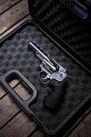 A gun in a case on a wooden floor photo