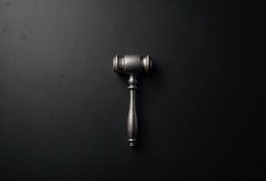 A silver gavel on a black background symbolizing justice and authority. photo