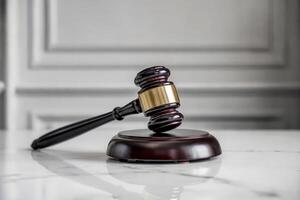 Wooden gavel and sound block on marble table in courtroom setting. photo