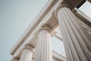 Close-up of majestic white stone columns under a clear blue sky. photo