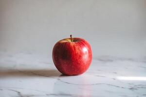 Fresh red apple on a marble surface with natural lighting. photo