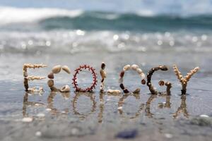 Shells and coral spell 'ECOLOGY' on a sandy beach reflecting sunlight. photo