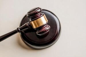 Wooden judge's gavel on a sound block in a courtroom setting. photo