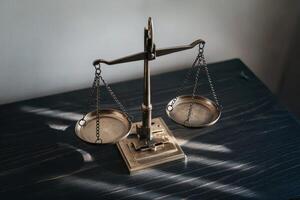 Brass balance scales on a dark wooden table, symbolizing justice and law. photo