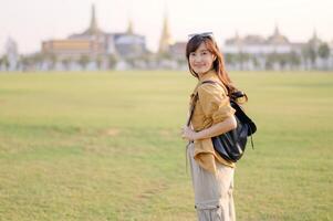 A Traveler Asian woman in her 30s exploring Wat Pra Kaew. From stunning architecture to friendly locals, she cherishes every moment, capturing it all in her heart and camera for years to come. photo