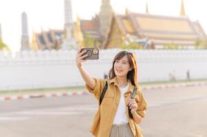Traveler asian woman in her 30s explores the Grand Palace with a local guide. Uncover hidden gems and immerse yourself in Thai culture with her adventure. photo